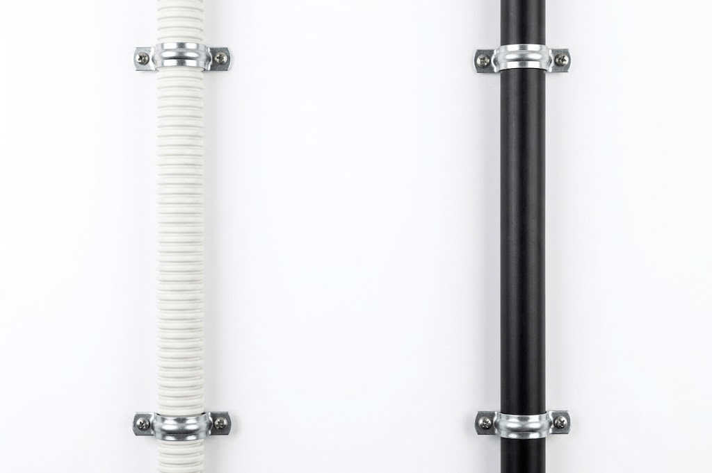 Black rigid PE pipe (straight runs) and white flexible CD conduit (bends).
